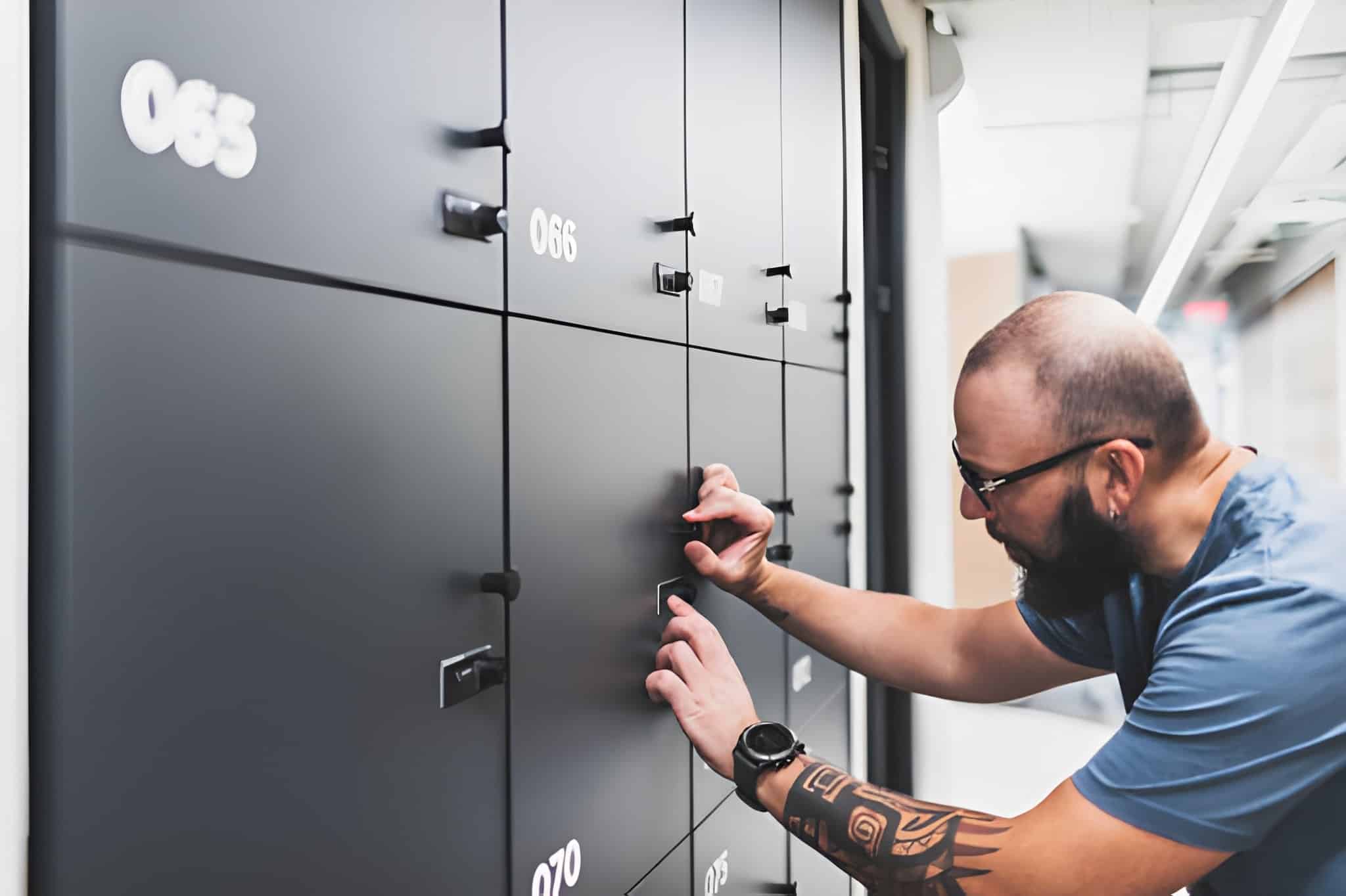 Adult man opening his locker at modern coworking